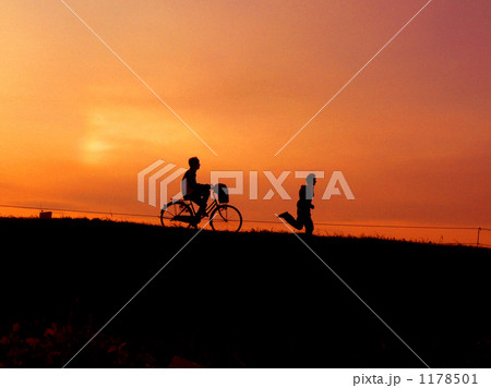 夕焼け 自転車 ジョギング 土手の写真素材
