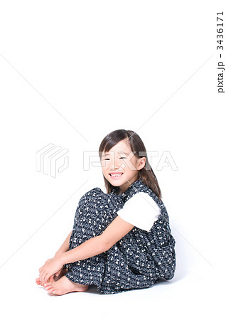 小学生 座る 体育座り 膝を抱えるの写真素材