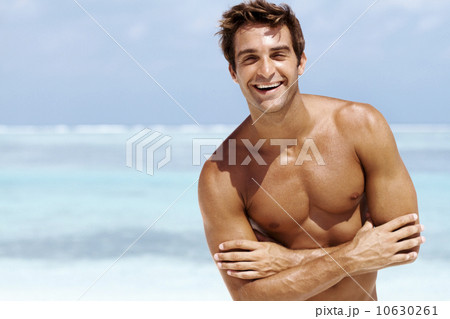 Portrait of shirtless muscular man standing with arms crossed