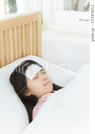 体調不良 寝る 女の子 熱の写真素材