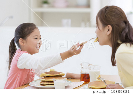 親子 食べさせる パンケーキ 娘の写真素材