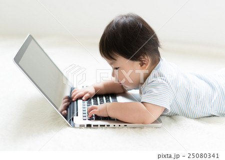 赤ちゃん ノートパソコン 興味 触るの写真素材
