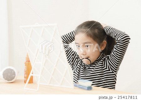 子供 ヘアゴム 鏡 女の子の写真素材