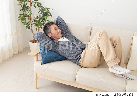 男性 ソファー 寝る 昼寝の写真素材