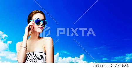 サングラスをかけた外国人女性と夏の空の写真素材