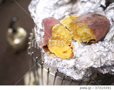 焼き芋 ストーブ アルミホイル焼き さつまいもの写真素材