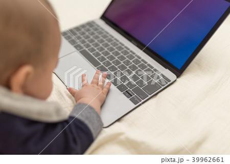 赤ちゃん ノートパソコン 興味 触るの写真素材