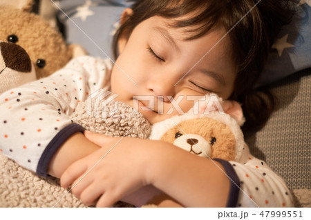 眠る 子供 寝る ぬいぐるみの写真素材