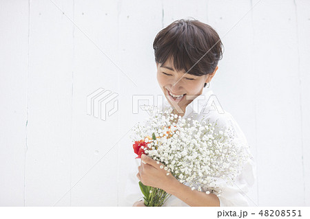 女性 花束 抱える 花の写真素材