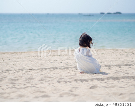 女の子 白いワンピース 海 風の写真素材