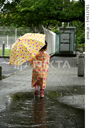 後ろ姿 レインコート 傘 女の子の写真素材