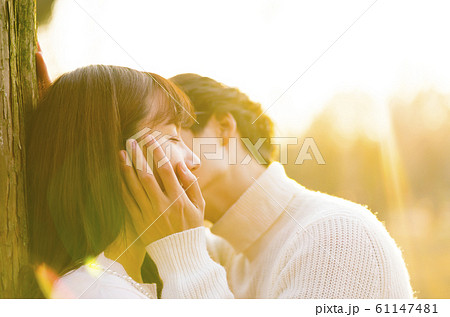 キス ウエディング 夕日 逆光の写真素材