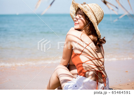 浜辺に座る水着姿の女性