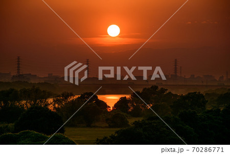 河川敷 土手 夕日 空 太陽の写真素材