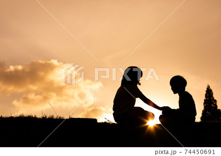 男の子 子供 夕焼け 夕日の写真素材