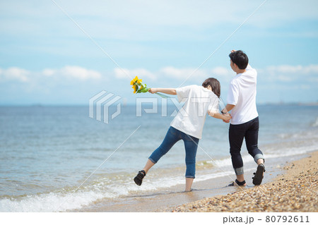 後ろ姿 ビーチ 海 カップルの写真素材