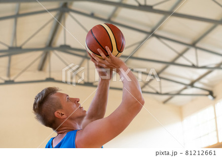 a war invalid in a wheelchair trains with a ball at a basketball club in training with professional sports equipment for the disabled. the concept of sport for people with disabilities