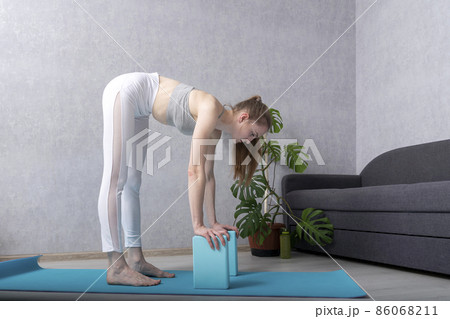 Young Woman Practices Side Plank Asanas with Yoga Blocks. Pilates