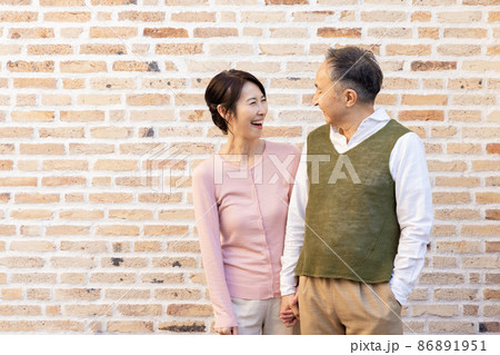 寄りかかる 女性 壁 人物の写真素材