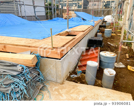 ブルーシートが掛けられた集合住宅の基礎工事の現場