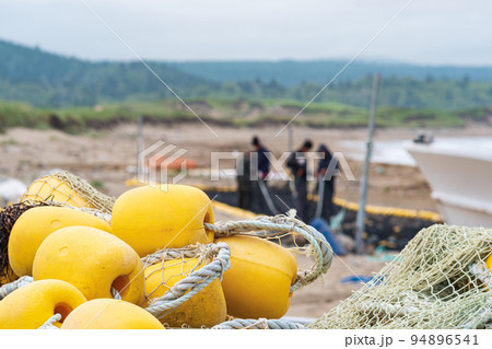 industrial fishing nets with bright floats is folded ashore