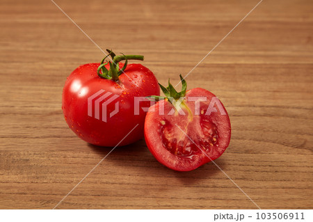 Front view of a ripe fresh tomato and halves ofの写真素材